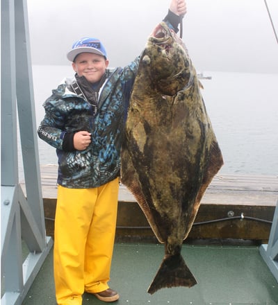 Young Cash Burns shows off his 92 lb alaska halibut.